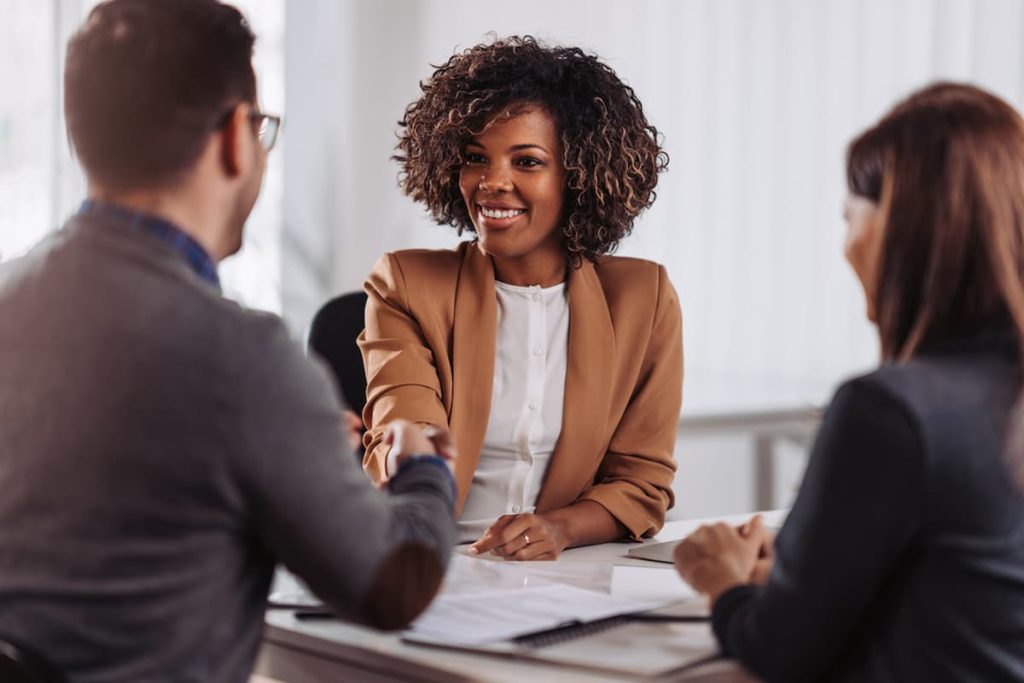 PJ ou CLT: Qual a melhor opção na hora de contratar? Mulher dando a mão para funcionário recém contratado como CLJ ou PJ na Weein agência de marketing digital